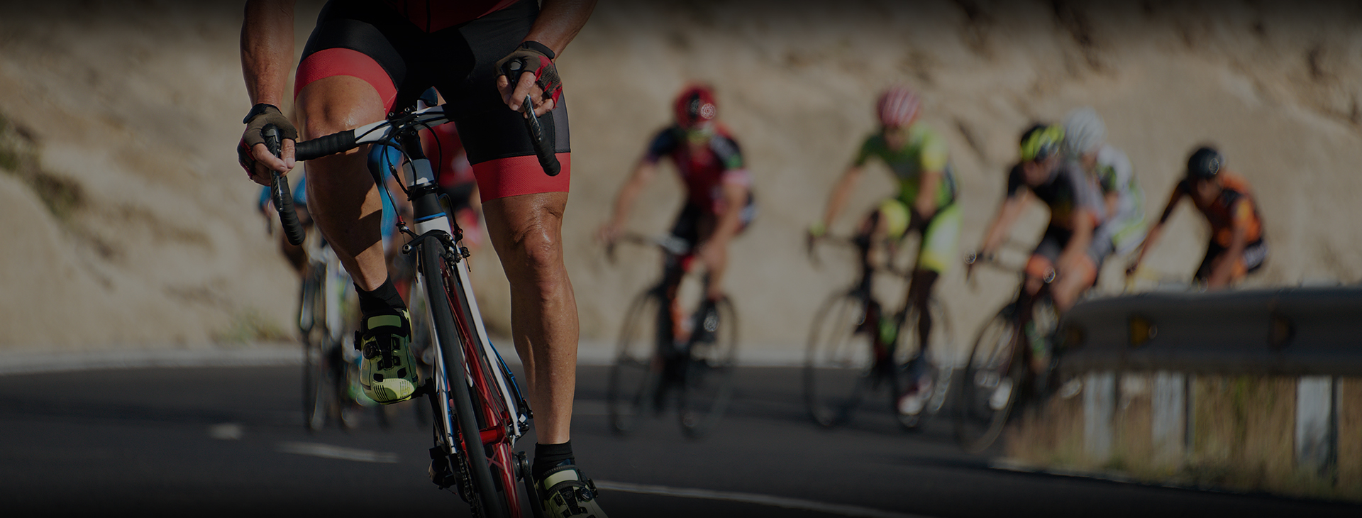 Lead cyclist in custom cycling bib and jersey riding in a competitive road cycling peloton.